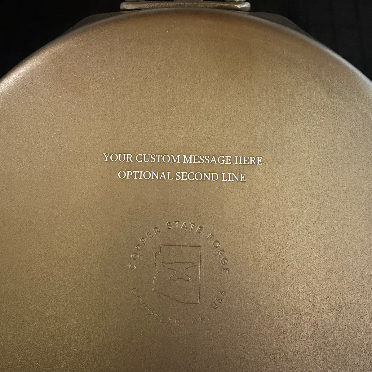 Custom laser engraving example: two lines of text above the Copper State Forge logo